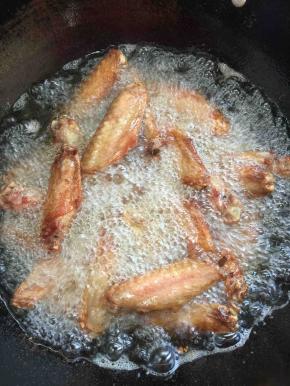 锅烧热倒入适量的油烧至七成热，放入腌制好的鸭翅，中火慢慢的炸！