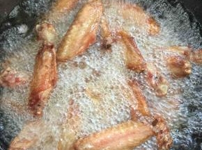 锅烧热倒入适量的油烧至七成热，放入腌制好的鸭翅，中火慢慢的炸！