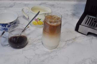 用叉子或者勺子抵住杯的边沿，缓缓将咖啡液注入，制造出分层的效果即可。（倾斜的角度大一点更有利于分层）