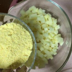 把水倒掉，捞起土豆块，保证土豆块湿润一点就好，倒入玉米面拌匀，让土豆块均匀裹上面粉