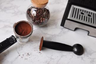 用量勺的另一端垂直向下挤压咖啡，不要压得太紧。不要超过滤网的最大刻度。