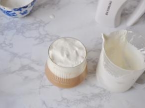 打到5分发程度，这时的淡奶油呈可以缓缓流动的细腻绵密状态。将打发好的淡奶油倒入调好的咖啡里，不用搅拌