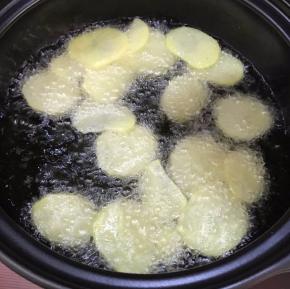 待油温升高，放入土豆片，炸至金黄色后捞出控油。