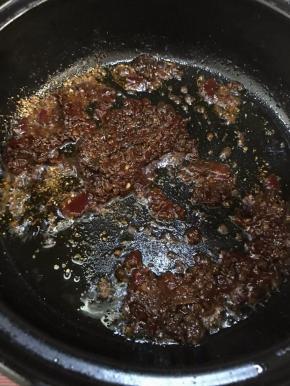将锅中油倒出，留少许在锅中，放入麻辣香锅底料，炒出香味。