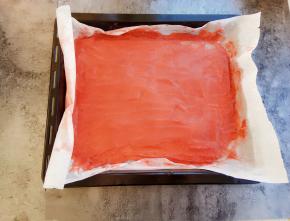 用刮刀慢慢把山楂泥刮平，油纸放入烤盘