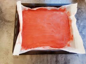 用刮刀慢慢把山楂泥刮平，油纸放入烤盘