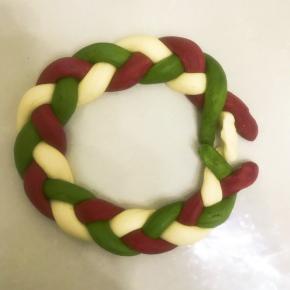 11把辫好的辫子慢慢整理成圆形，头尾相接，颜色对颜色接起来，接口处一定要捏紧，不然烤的时候会开裂。