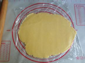 将面团放在两张保鲜膜中间，用擀面棍擀成薄面片