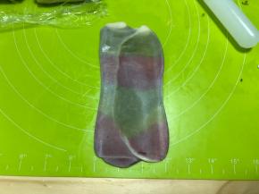 然后取卷好的面卷再次擀开，依旧是顺着油酥竖着的方向擀开