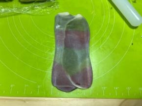 然后取卷好的面卷再次擀开，依旧是顺着油酥竖着的方向擀开