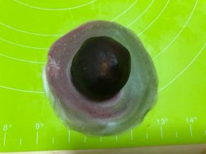 把馅料滚圆，包入面皮内