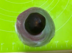 把馅料滚圆，包入面皮内