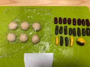 油酥材料混合，揉匀即可，图中我还做黄色的油酥，将水油皮分为32g左右一个的面团，盖上保鲜膜，防止变干，油酥分为5g一个的小面团，揉成条状，一个水油皮对应4小份油酥