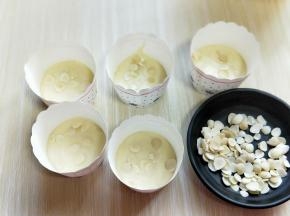 将蛋糕液倒入蛋糕杯的3/1，加入杏仁。