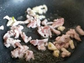 加入切碎的蒜，肉丝煸炒，炒至发白，加入一勺料酒继续煸炒。