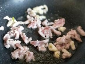 加入切碎的蒜，肉丝煸炒，炒至发白，加入一勺料酒继续煸炒。