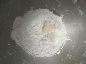 依次将酸奶、鸡蛋、砂糖、高筋面粉、全麦粉放入厨师机搅拌桶，再加入酵母，启动厨师机和面