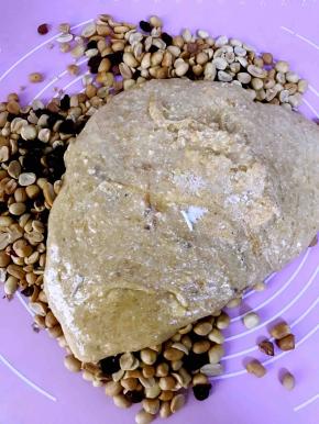 将烤箱里的花生米和蔓越莓倒在硅胶垫上，将拌均匀的糖放在花生和蔓越莓上面，带上一次性手套，手套一定要带，使劲的揉，跟揉面一样，让花生仁和蔓越莓更好的融合在糖里面