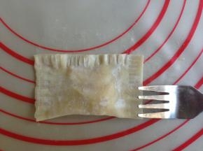 用叉子在云吞皮三条边压出叉痕，压紧一点，这样就不会爆开