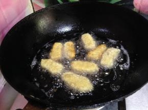 锅里倒入适量油烧至六成热，将挂满糊的奶块逐个放进去炸到表面金黄