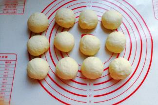将发酵好的面团取出挤压排气，分成均匀的12个小面团滚圆盖保鲜膜醒发15分钟左右；