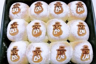 再溶一点黑白巧克力，分别装裱花袋，挤在雪人轮廓的脸部和围脖处，这样雪人模样就出来啦！