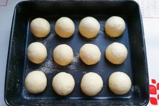 将醒发的小面团揉圆揉光滑，依次摆入烤盘中再次进行发酵；（如果不是不沾烤盘，可以先刷层植物油，再筛上一层薄薄的低粉防沾）