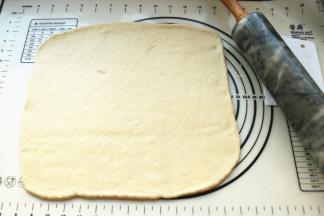 发酵好的面团按压排气后，分成两份。分别擀成长方形薄片。