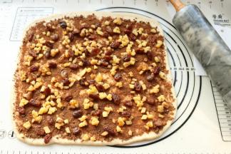 铺上肉桂糖粉。再铺上苹果丁和葡萄干。