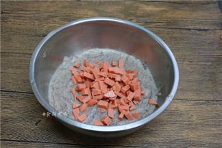 打好的玉米糊倒出不锈钢盆里，加上火腿肠粒；