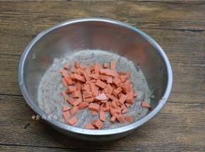 打好的玉米糊倒出不锈钢盆里，加上火腿肠粒；