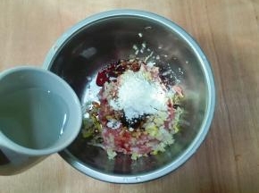 放玉米淀粉，放适量清水顺时针搅拌均匀至有黏性成肉馅