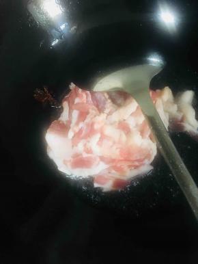 放入五花肉煸炒至变色