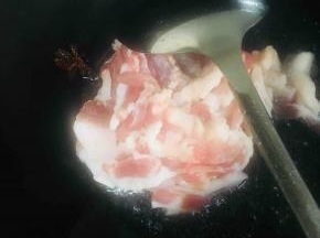 放入五花肉煸炒至变色