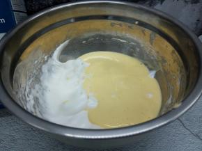 将拌匀的面糊倒入剩余的蛋白里，再次翻拌均匀即成戚风蛋糕面糊。倒入模具，振出大气泡