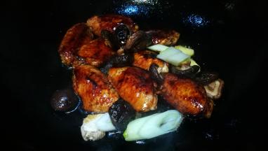 锅中油热焯鸡翅中 放入葱姜香菇翻炒