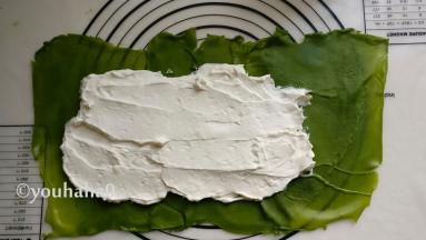 把淡奶油涂抹在饼皮的中间，大致抹平，饼皮的尾部不要放奶油