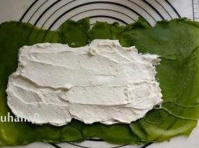 把淡奶油涂抹在饼皮的中间，大致抹平，饼皮的尾部不要放奶油