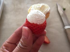 将草莓切半，中间挤上淡奶油，用黑芝麻当眼睛嘴巴