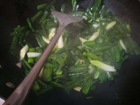 蒜白炒到变色后，放入蒜青