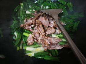 蒜青翻炒变色，马上放入牛肉片