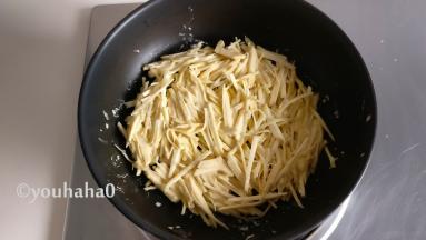 平底锅中放入适量的植物油，放入红薯丝铺满锅底，小火煎