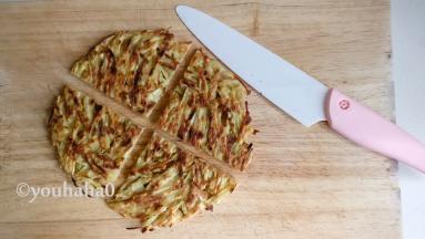 煎好的红薯饼在案板上，用刀切开
