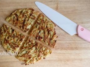 煎好的红薯饼在案板上，用刀切开