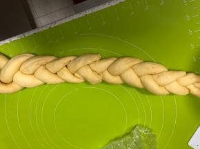 把3条面卷头部捏合，像编辫子一样编起来，另外三条从尾部粘上继续编