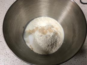 厨师机面盆内先倒入牛奶、全蛋液，然后倒入高筋面粉，盐和糖对角线放置，中间挖一小孔倒入活性干酵母