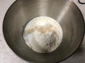 厨师机面盆内先倒入牛奶、全蛋液，然后倒入高筋面粉，盐和糖对角线放置，中间挖一小孔倒入活性干酵母