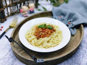 将煮熟的意大利面盛出放入盘中，再将番茄肉酱放在意大利面上面。