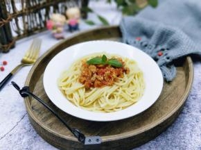 将煮熟的意大利面盛出放入盘中，再将番茄肉酱放在意大利面上面。