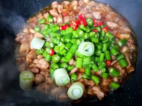 放入青椒、小红尖椒和大葱段翻炒均匀。